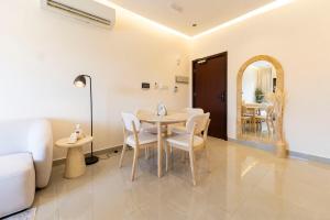 a dining room with a table and chairs and a mirror at Beige Apartment by Bait Zain - Bousher in Muscat