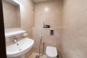 a bathroom with a sink and a toilet at Beige Apartment by Bait Zain - Bousher in Muscat +12 photos