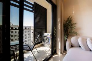 a living room with a view of a balcony at Beige Apartment by Bait Zain - Bousher in Muscat