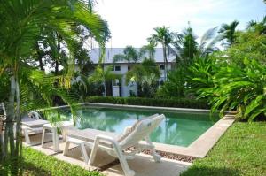 a swimming pool with two lounge chairs and a house at Samui Honey Tara Villa Residence in Choeng Mon Beach