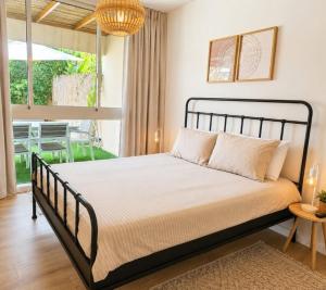a bedroom with a bed with a large window at סי מיה - דירות יוקרתיות במתחם נאות גולף in Caesarea
