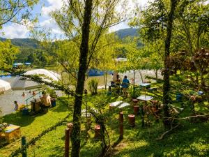 a park next to a river with people on the grass at Ecohotel El Amarradero in Alejandría
