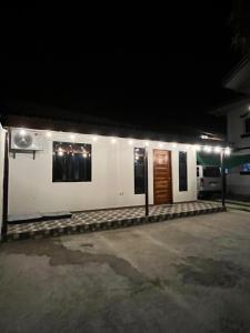 a white building with a door at night at Casa Jawero in Orani