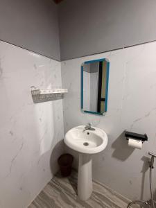 a white bathroom with a sink and a mirror at Casa Jawero in Orani +6 photos