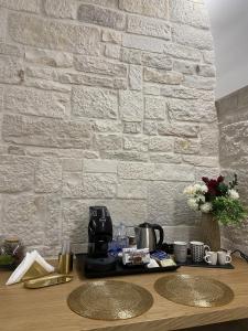 a kitchen counter with a coffee maker and a brick wall at Vénere maison de charme in Giovinazzo