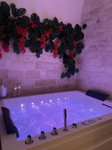 a jacuzzi tub in a room with red flowers at Vénere maison de charme in Giovinazzo