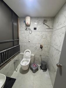 a small bathroom with a toilet and a sink at Hotel Planet Town in Ahmedabad +17 photos