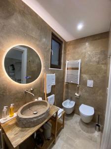 a bathroom with a sink and a toilet and a mirror at Vénere maison de charme in Giovinazzo