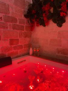 a red lighted hot tub in a room with red lights at Vénere maison de charme in Giovinazzo