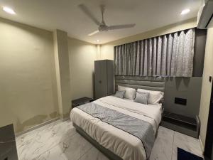 a bedroom with a bed and a ceiling fan at Hotel Planet Town in Ahmedabad