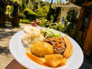 a plate of food with meat and vegetables and potatoes at Ecohotel El Amarradero in Alejandría