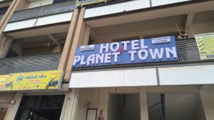 a hotel planet town sign on the side of a building at Hotel Planet Town in Ahmedabad