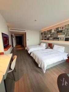 a hotel room with two beds and a table and chairs at Ibis Haiyan Economic Development Zone in Haiyan