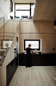 a woman standing at a counter in a kitchen at Meteorite House in Kontiolahti