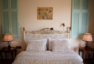 a bedroom with a bed with two lamps and two windows at Panorama Penthouse & Studios in Athens