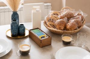 a table with a basket of bread and a box of coffee at That's Amore Cernobbio - Lake Como Apartment in Cernobbio
