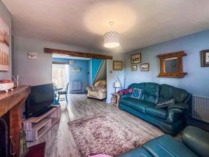 a living room with a couch and a television at Penny Cottage in Heacham
