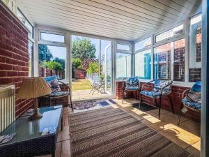 a living room with windows and a table and chairs at Penny Cottage in Heacham +9 photos