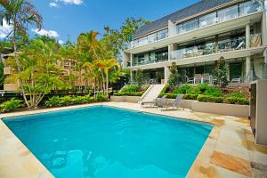 a swimming pool in front of a building at Headland Views Apartments in Noosa Heads