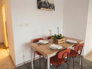 a dining room table with chairs and a white wall at the LOFT - Elite Residence in Cairo