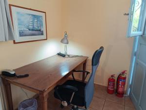 a wooden desk with a lamp and a chair at Seaside olive grove in Pyrgi Thermis