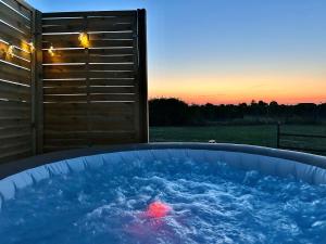 a hot tub with a red ball in it with a sunset at L’Orée des Vignes in Saint-Sulpice-de-Faleyrens