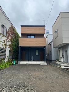 a house with a blue door in a parking lot at 宿中村屋 in Aomori