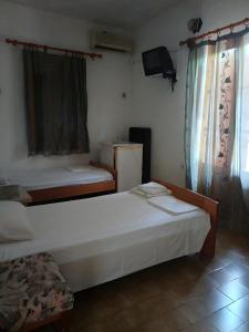 ein Schlafzimmer mit zwei Betten und einem Fernseher in der Unterkunft Orama in Vasiliká