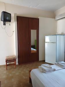 ein Zimmer mit zwei Betten und einem Kühlschrank und einem Spiegel in der Unterkunft Orama in Vasiliká
