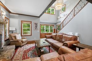 a living room with brown leather furniture and stairs at The Moose House by Juniper Holiday + Home in New Buffalo +52 photos