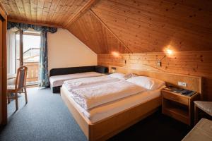 a bedroom with two beds in a wooden room at Grillhofer - Slow Living Apartments -LUNGAUCard inkludiert in Mauterndorf