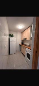 a kitchen with a white refrigerator and a dishwasher at Beach Palo Malaga in Málaga