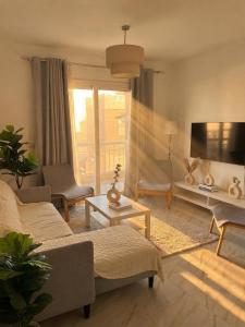 a living room with a couch and a tv at the LOFT - Elite Residence in Cairo
