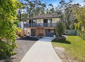 a house with a balcony and a driveway at Tranquil Waters Edge Escape in Sanctuary Point
