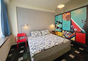 a small bedroom with a bed and a red chair at Avery case in Tainan