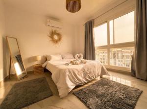a bedroom with a white bed and a large window at the LOFT - Elite Residence in Cairo