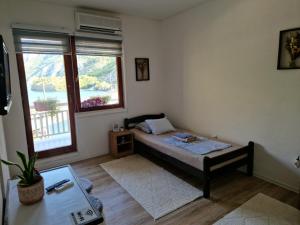a small bedroom with a bed and a window at Visit Dreznica - Canyon Retreat in Mostar