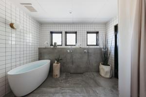 a white bathroom with a tub and a shower at o ku in Awaji +8 photos