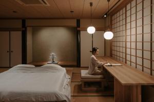 a woman sitting at a desk in a room at o ku in Awaji