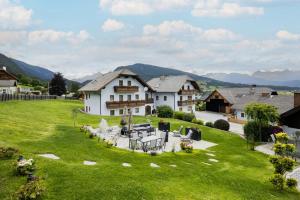 a large house in a green field with mountains in the background at Grillhofer - Slow Living Apartments -LUNGAUCard inkludiert in Mauterndorf
