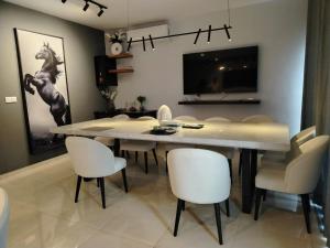 a dining room with a table and chairs and a tv at Villa 80 in Gonapola