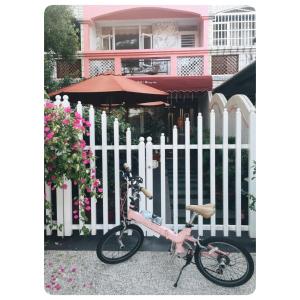 a pink bike parked next to a white fence at Qing Noise Villas in Hualien City