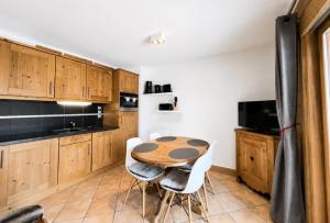 a kitchen with wooden cabinets and a table and chairs at Chalet Adele - Appartement 4 personnes situé en bord de piste St Martin de Belleville MAE-5684 in Saint-Martin-de-Belleville