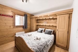 a bedroom with a bed with two stuffed animals on it at Chalet Adele - Appartement 4 personnes situé en bord de piste St Martin de Belleville MAE-5684 in Saint-Martin-de-Belleville
