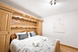 a bedroom with a large bed with a wooden headboard at Chalet Adele - Appartement 4 personnes situé en bord de piste St Martin de Belleville MAE-5684 in Saint-Martin-de-Belleville