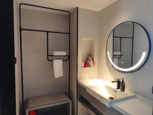 a bathroom with a sink and a mirror at Ibis Haiyan Economic Development Zone in Haiyan