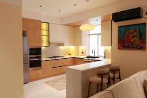 a kitchen with wooden cabinets and a white counter top at PANA Apartments in Nukus