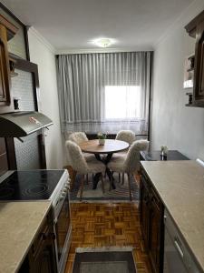a kitchen with a table and chairs and a window at TAMARIS Apartment in Subotica