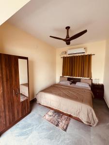 a bedroom with a bed and a ceiling fan at Kadapu stay in Udiyāvara