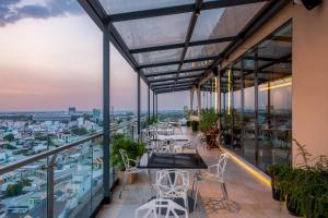 a view from the balcony of a building with tables and chairs at The IRIS SIGNATURE HOTEL AND SPA in Can Tho